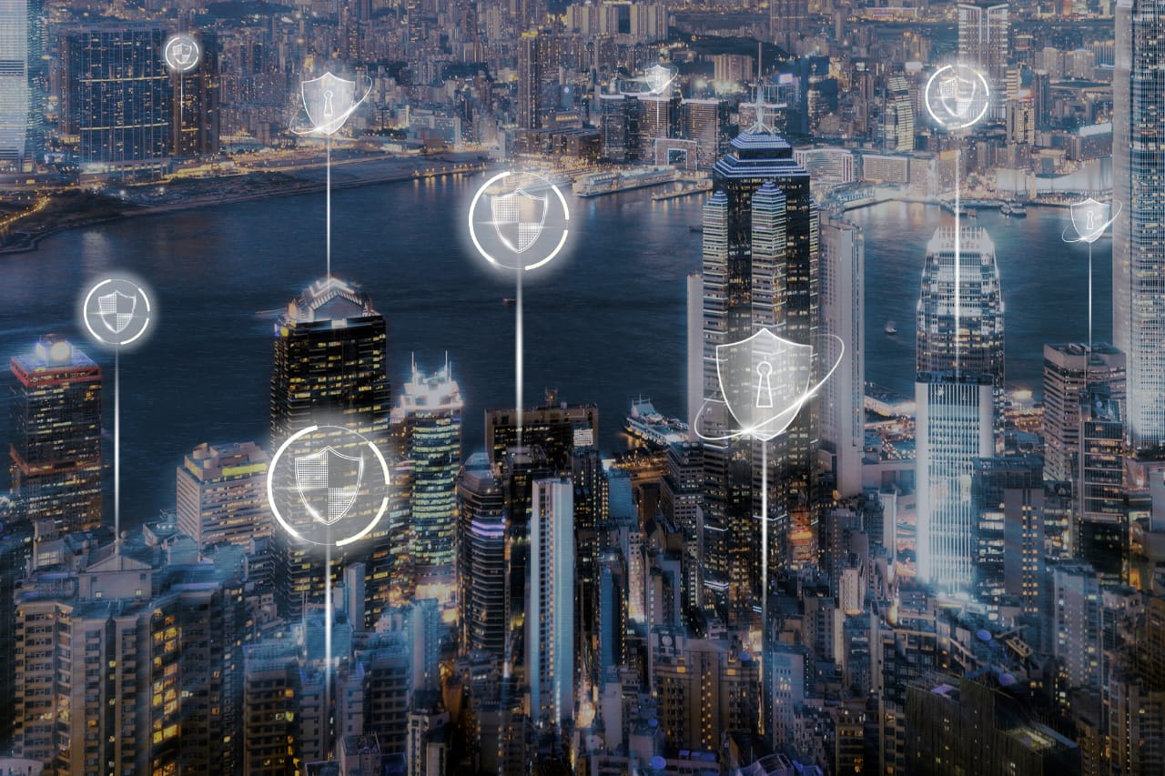 City skyline at night with digital security shield overlays